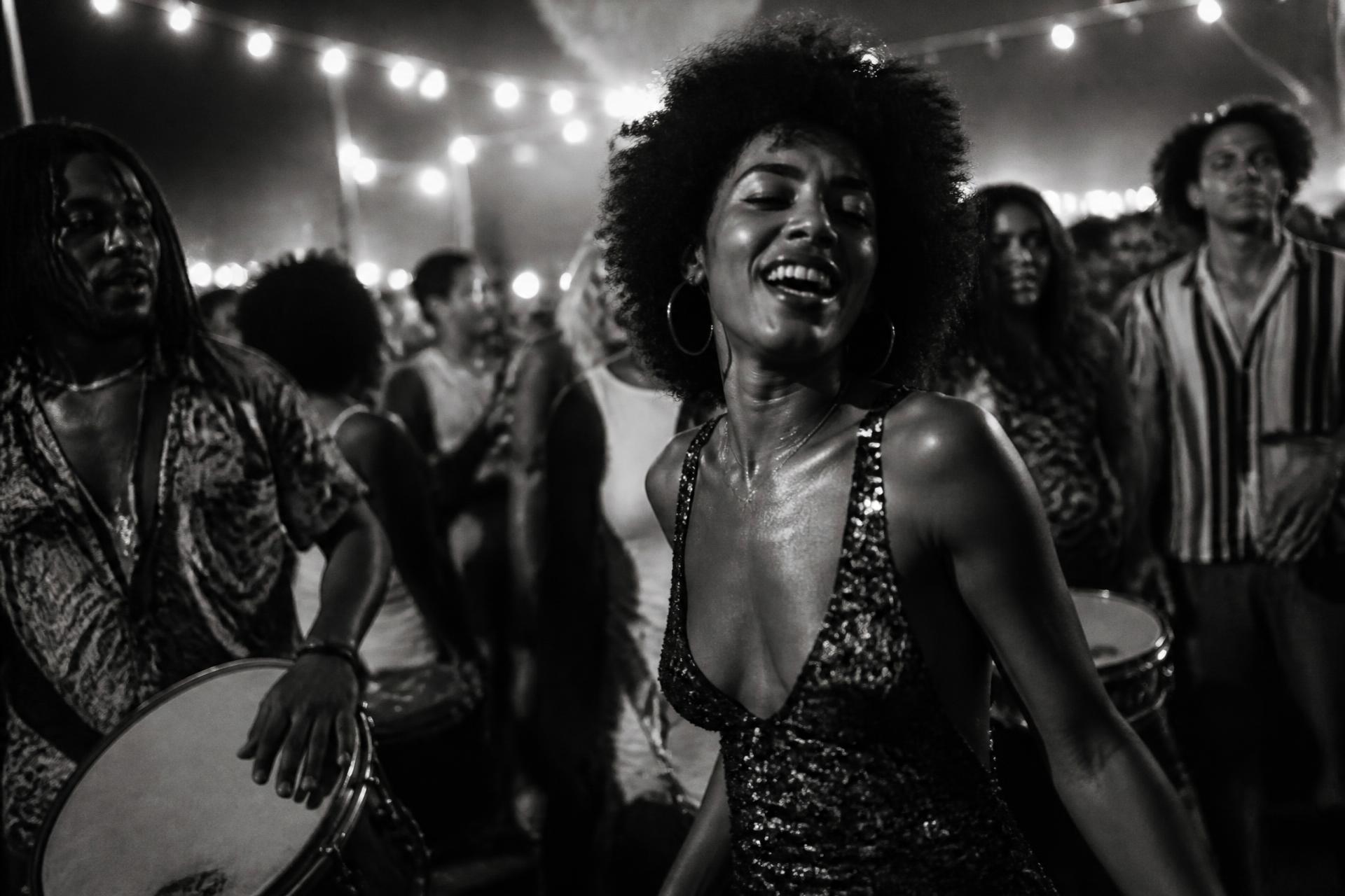 Mulher em ambiente de roda de samba em preto e branco